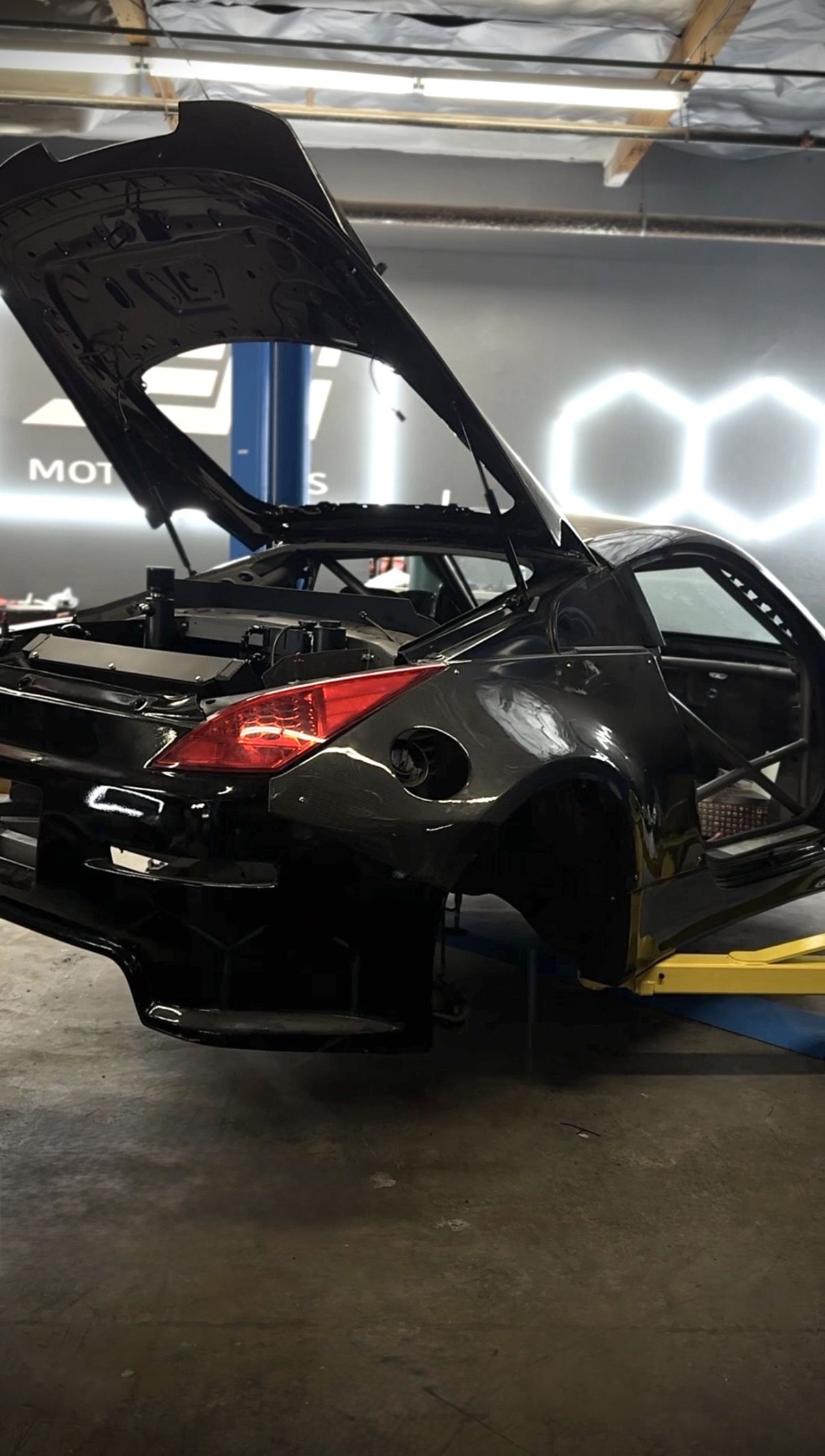 The DEFI Motorsports in-house race car, a stripped widebody Nissan Z with an LS swap, on the lift in Corona, California