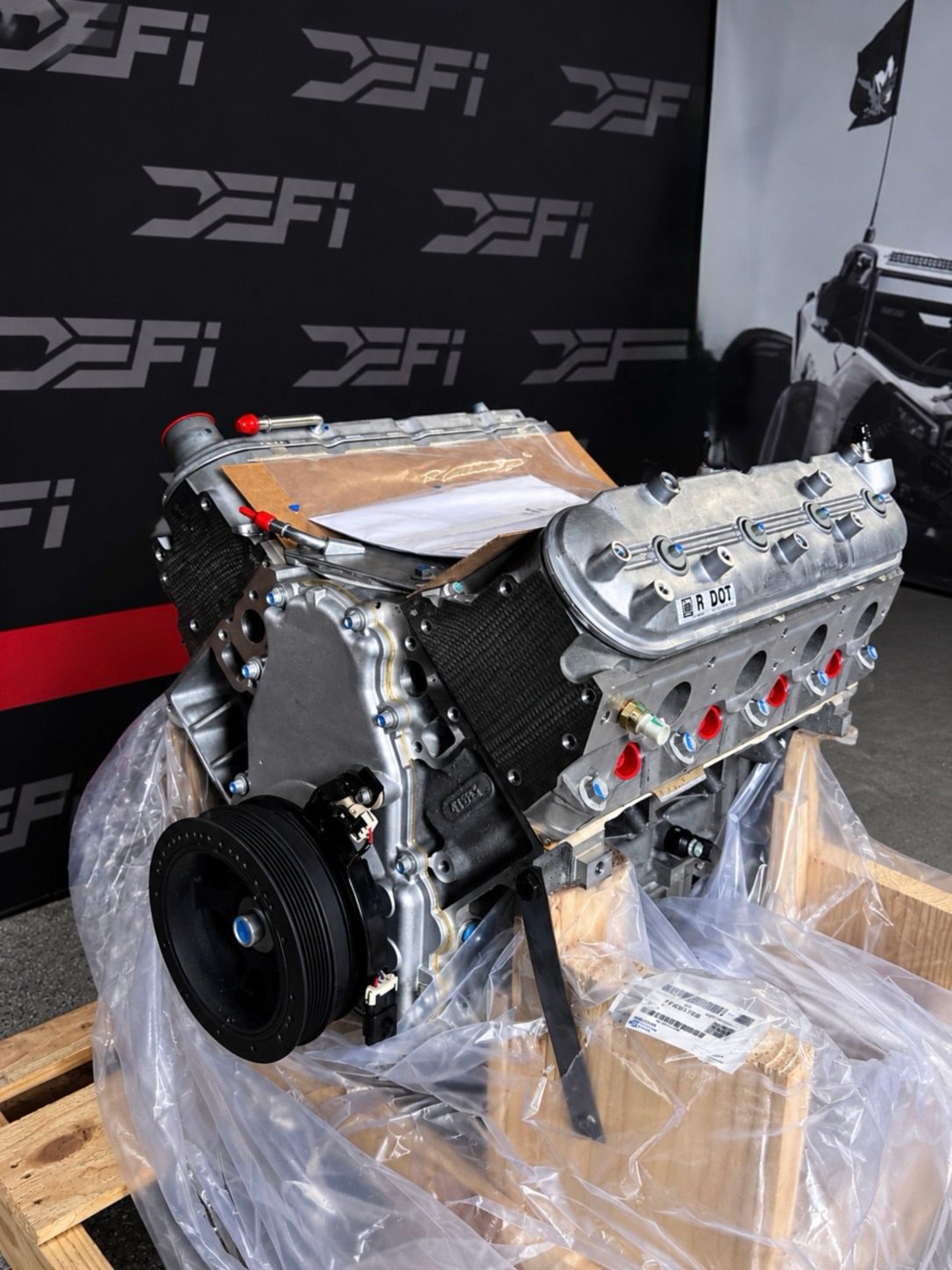 New GM LS3 430 hp long block crate engine in its shipping crate in front of the DEFI Motorsports wall in Corona, California